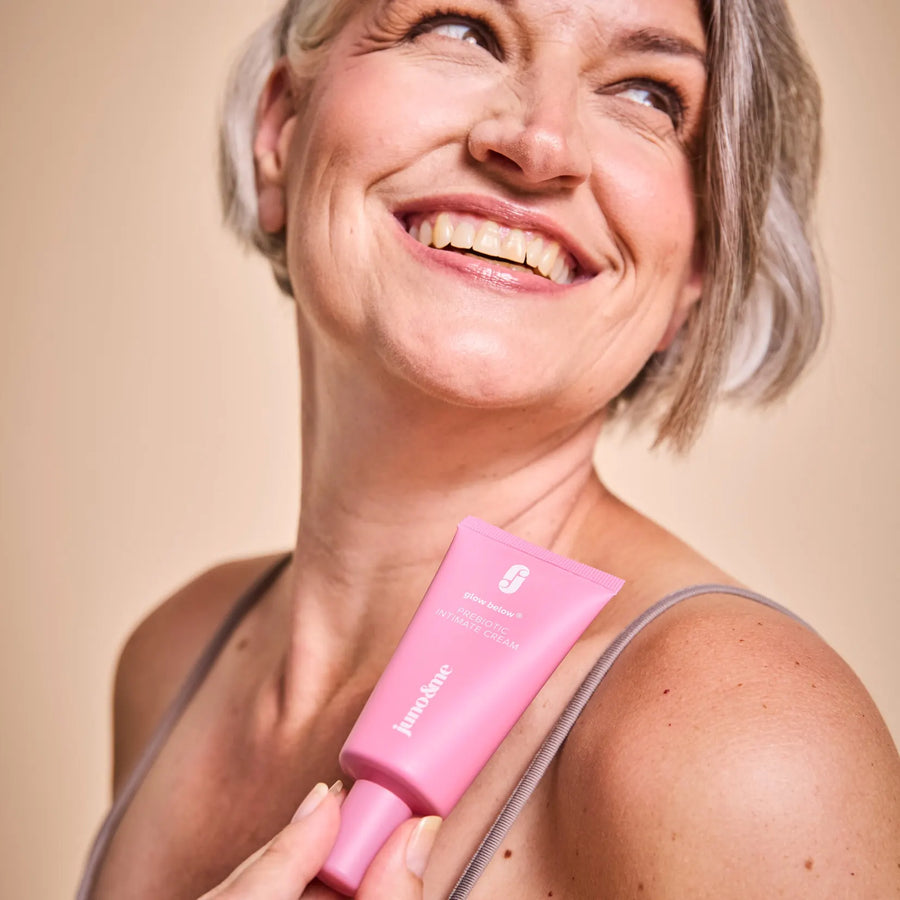 Lachende Frau mit grauem Haar hält die Prebiotic Intimate Cream