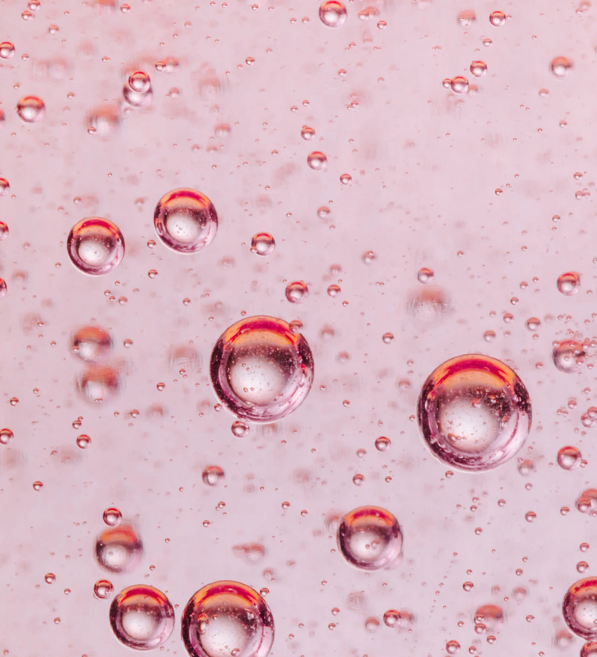 Transparente Rosa Flüssigkeit mit schwebenden Luftblasen.