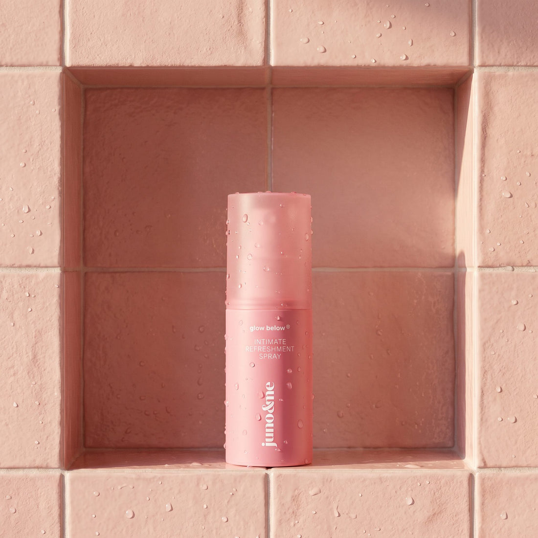 Intim Deo in a pink shower niche with water droplets