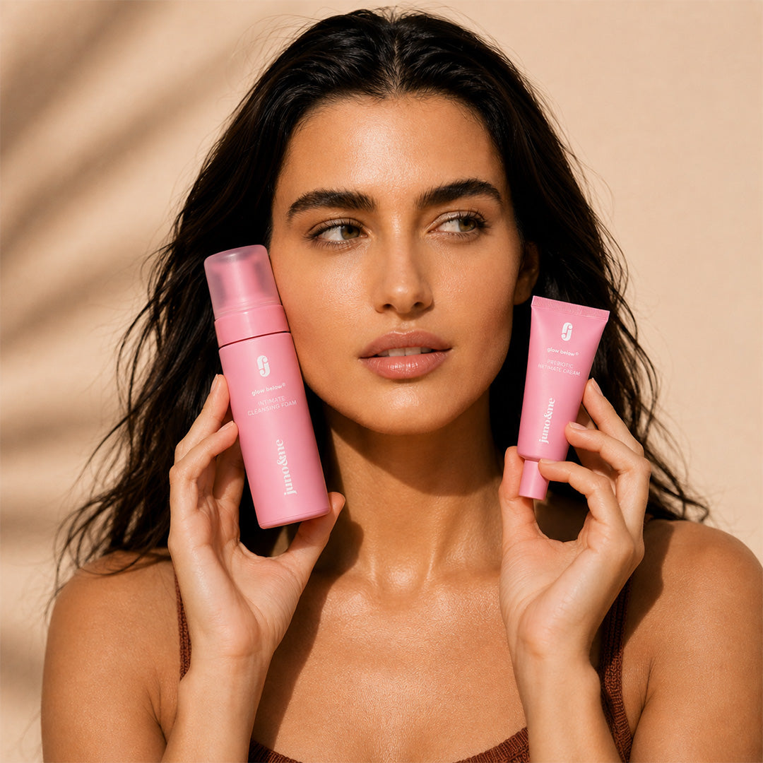 Woman holding the Intimate Cleansing Foam and Prebiotic Intimate Cream of the Happy Vulva Duo next to her face