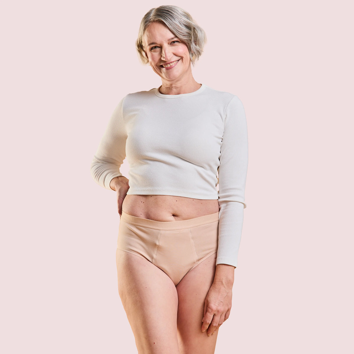Laughing woman in a grey top wearing the Incontinence Panty Strong in nude