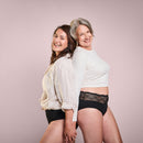 Zwei Frauen tragen Inkontinenz Panties black Duo, stehen beieinander und lächeln.
