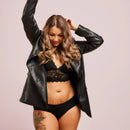 Frau trägt schwarze Periodenunterwäsche Feel-Good-Day-and-Night mit spitzen BH und lächelt.