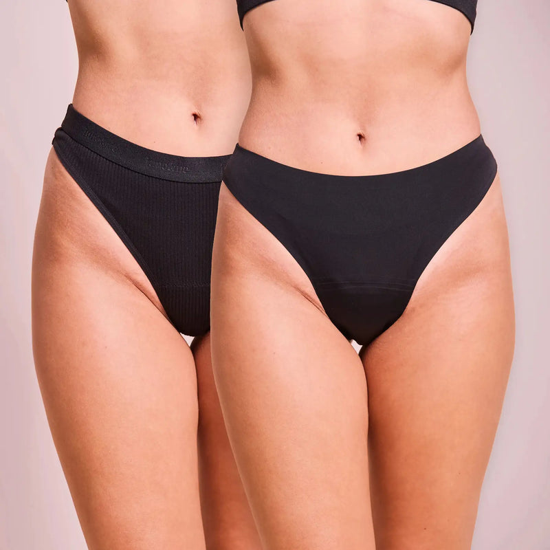 Period Panty String Duo von juno&me: Ribbed Cotton String und Seamless String in Schwarz, nebeneinander getragen