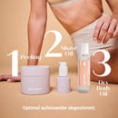 Body Crush Trio in 3 Schritten: Peeling, Rasieröl und Trockenöl vor einer sitzenden Frau, juno&me
