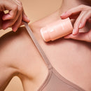 Frau trägt den Bodyguard Skin Protection Stick unter den beigen Träger auf.
