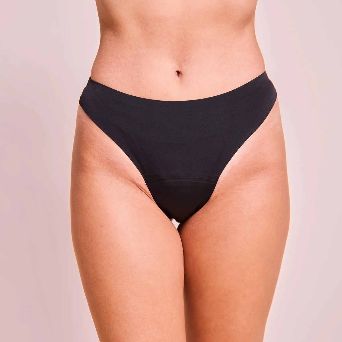 Schwarzer seamless panties wird von Person getragen, mit neutralem Hintergrund.