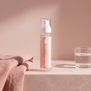 Dekolleté Serum auf einer Badezimmerablage neben einem Handtuch