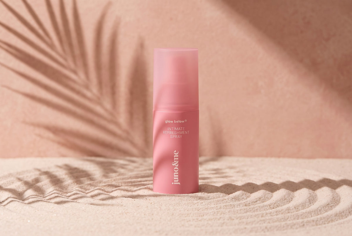 Intim Deo standing in pale sand in front of a pink wall with a palm shadow
